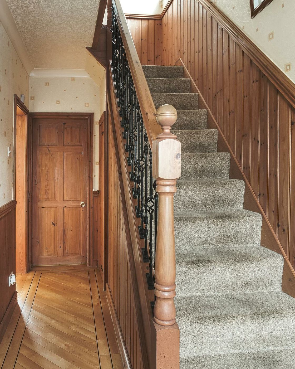 Hallway and staircase before: wood panelling and patterned wallpaper